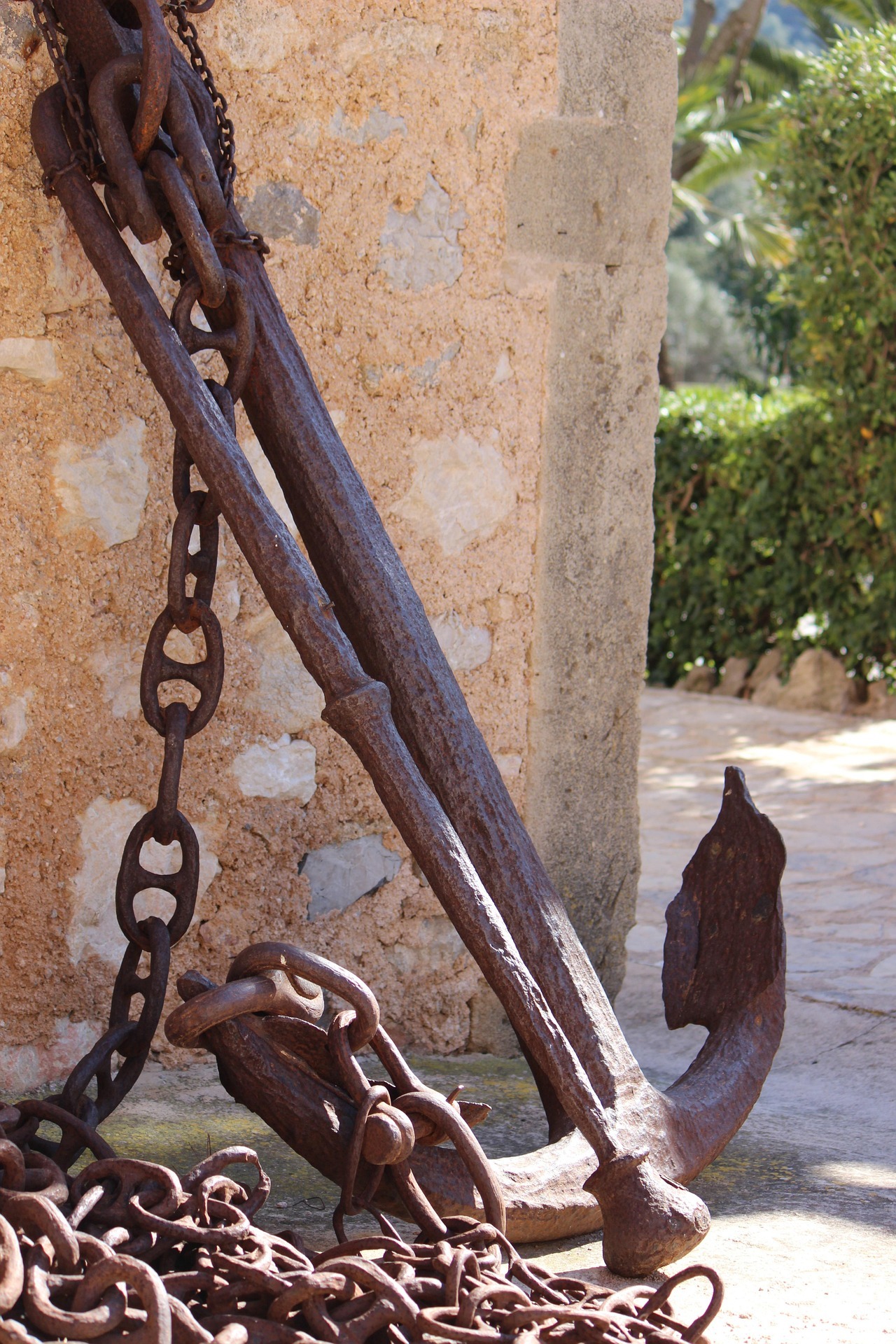 Rusty old anchor against a stone wall Rusty old anchor against a stone wall