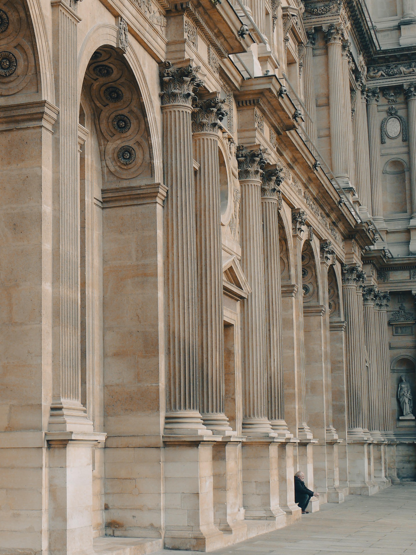 Man waiting sitting in the arches of architecture landmark monument