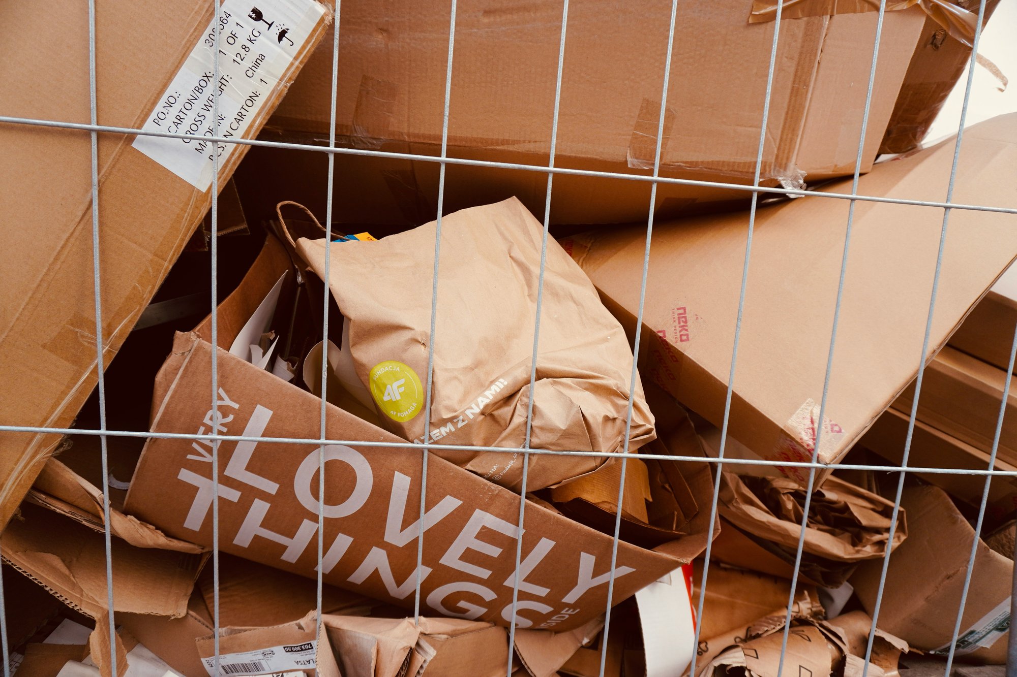 A collection of cardboard boxes in a recycling cage