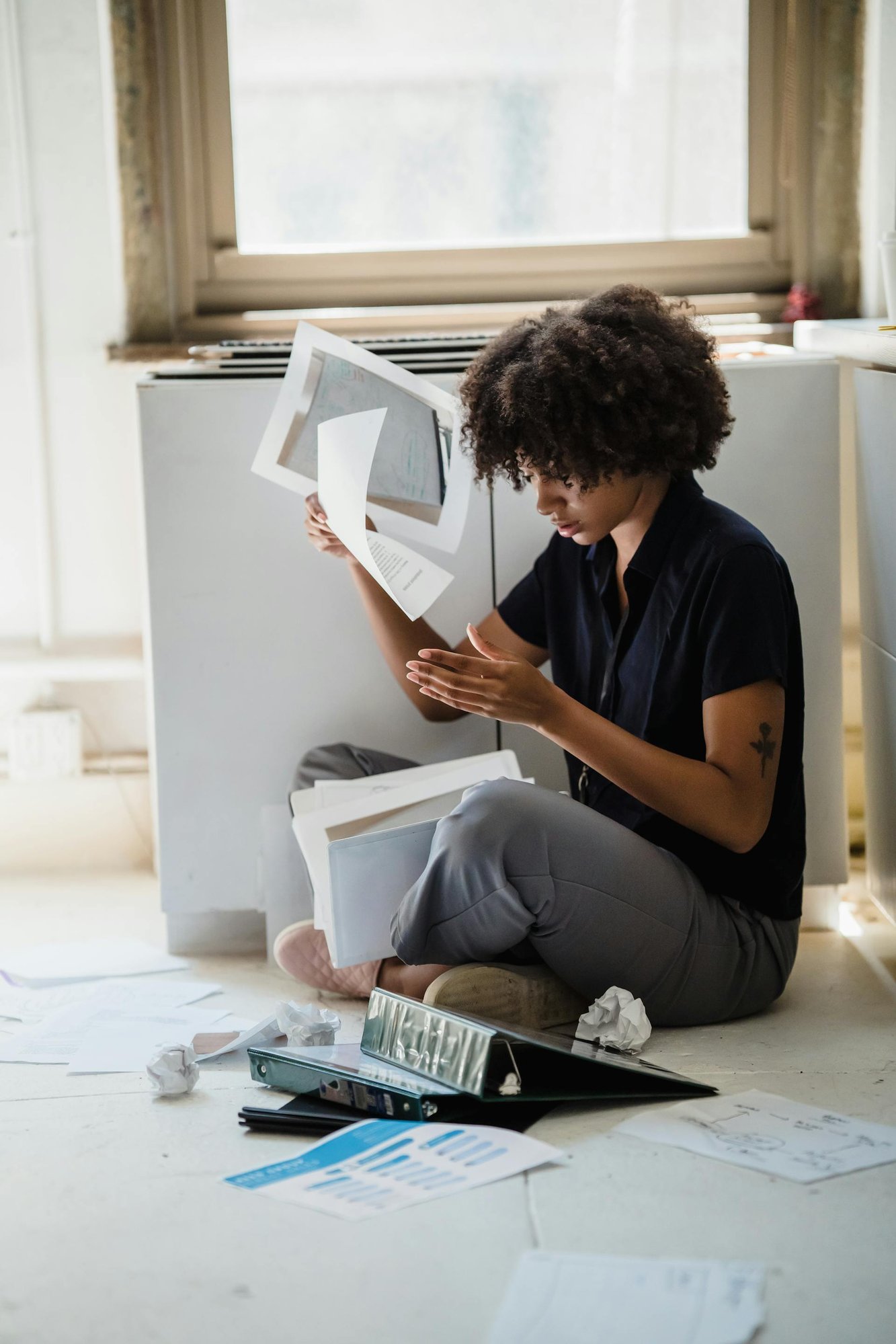 Woman Sitting on Floor Sorting Documents Woman Sitting on Floor Sorting Documents