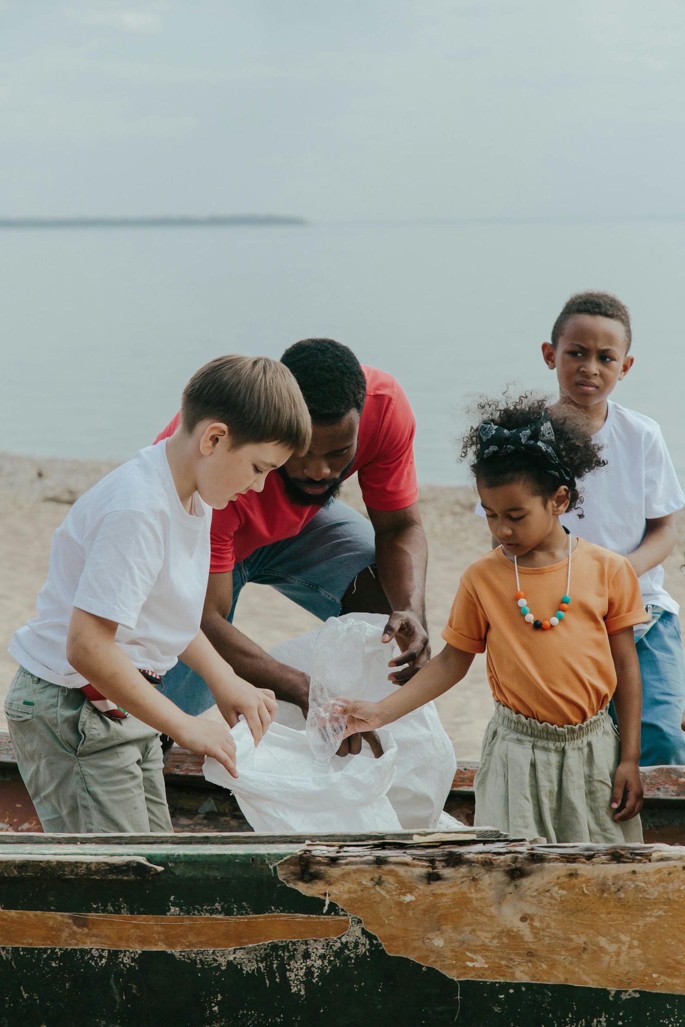 Adults and children cleaning the beach