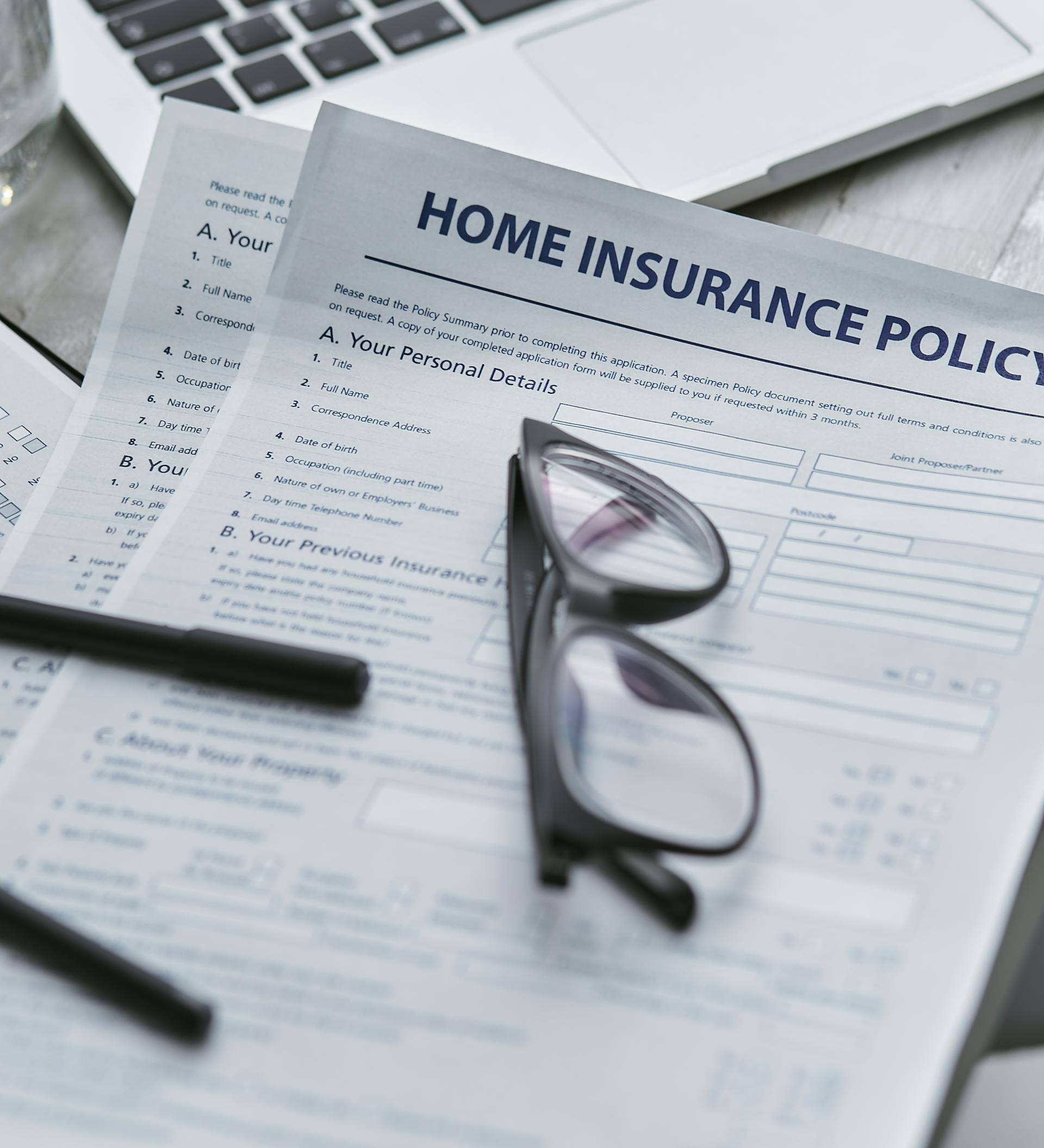 Home insurance form with spectacles laying on top Home insurance form with spectacles laying on top